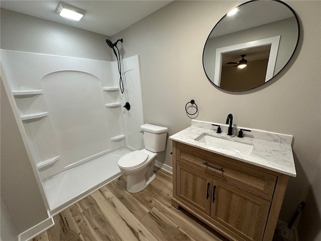 bathroom with a shower, vanity, wood-type flooring, and toilet