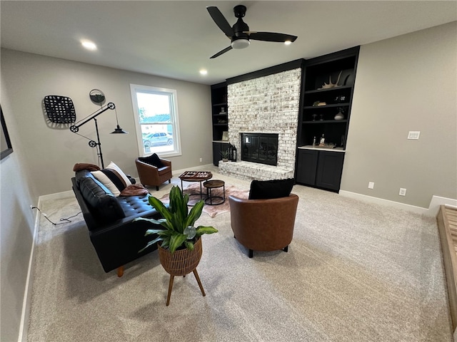 carpeted living room with ceiling fan, built in features, and a brick fireplace