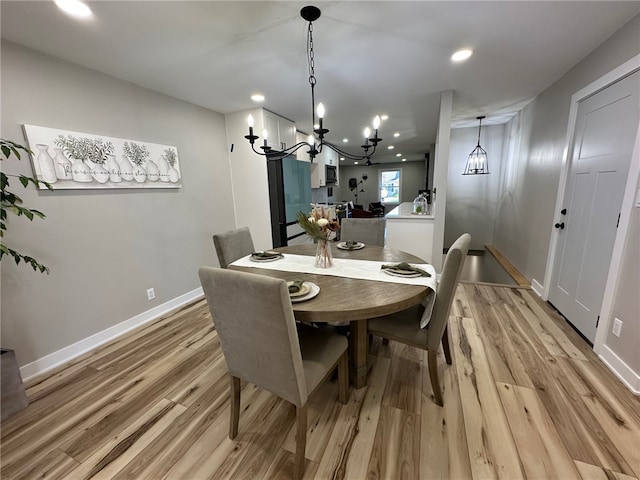 dining area featuring light hardwood / wood-style flooring and a notable chandelier