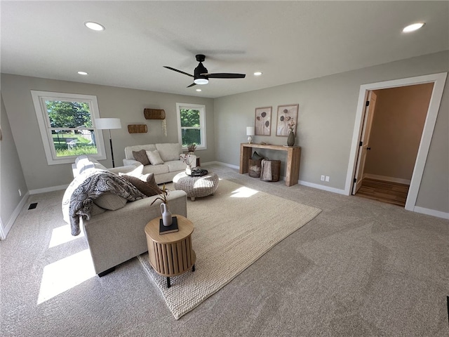 living room with ceiling fan and light colored carpet