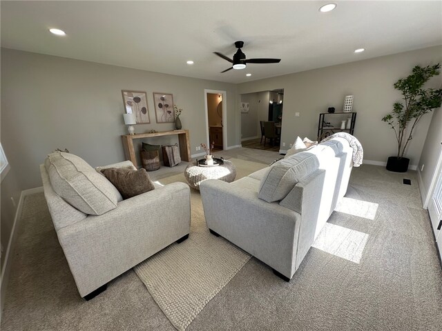 living room with ceiling fan and light colored carpet