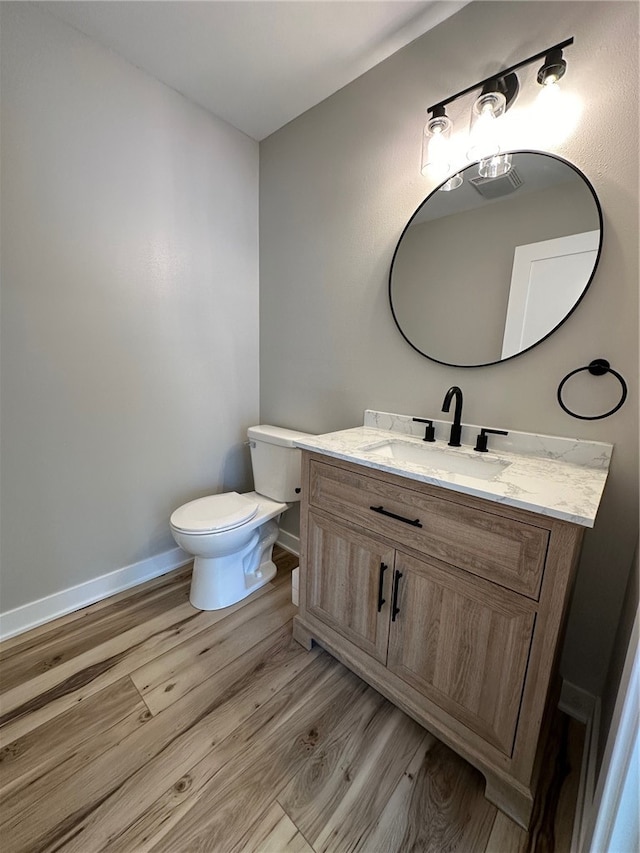 bathroom featuring vanity, toilet, and wood-type flooring