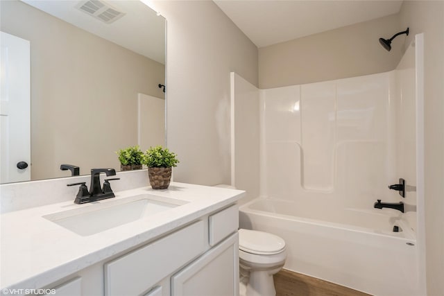 bathroom featuring visible vents, toilet, vanity, shower / tub combination, and wood finished floors