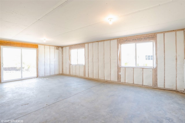 unfurnished room with unfinished concrete flooring