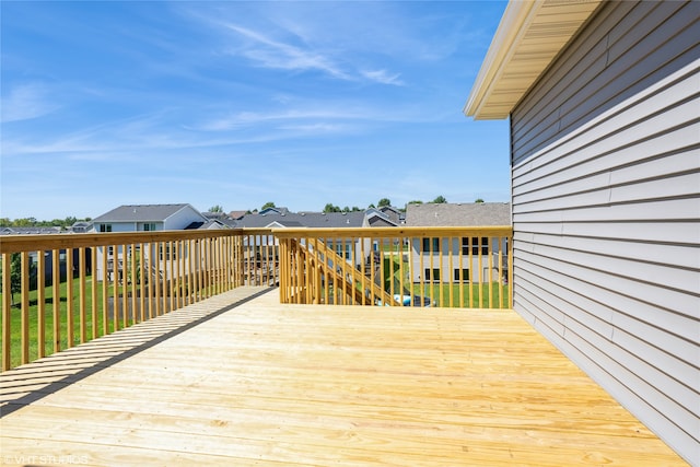 wooden terrace featuring a residential view and a yard