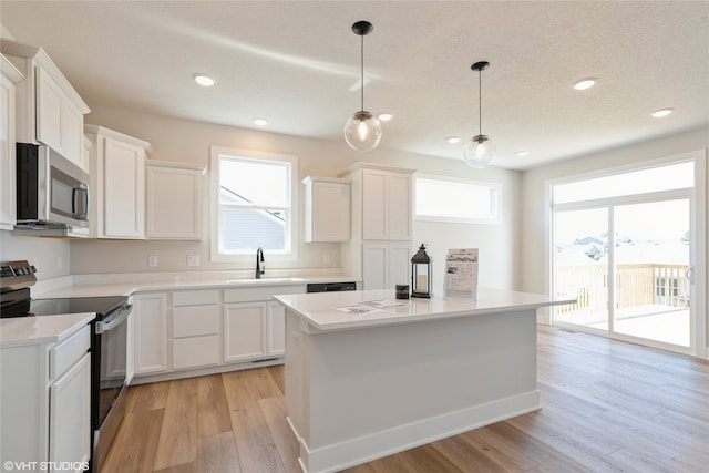 kitchen featuring appliances with stainless steel finishes, plenty of natural light, and white cabinets