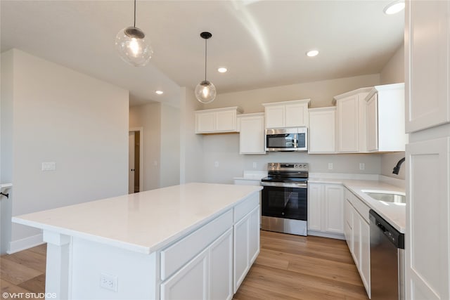 kitchen with a center island, appliances with stainless steel finishes, white cabinetry, and sink