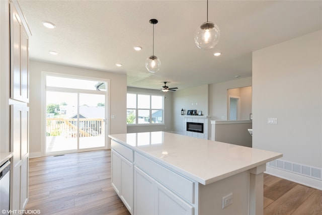 kitchen featuring light wood-type flooring, ceiling fan, and white cabinets