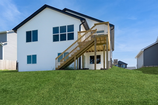 rear view of property featuring a lawn and cooling unit