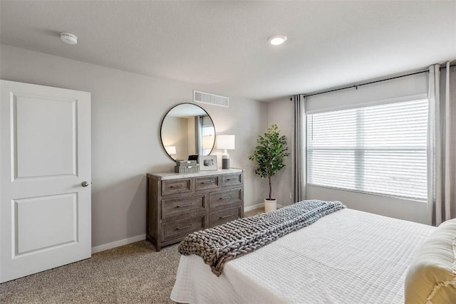 bedroom with baseboards, visible vents, and light colored carpet