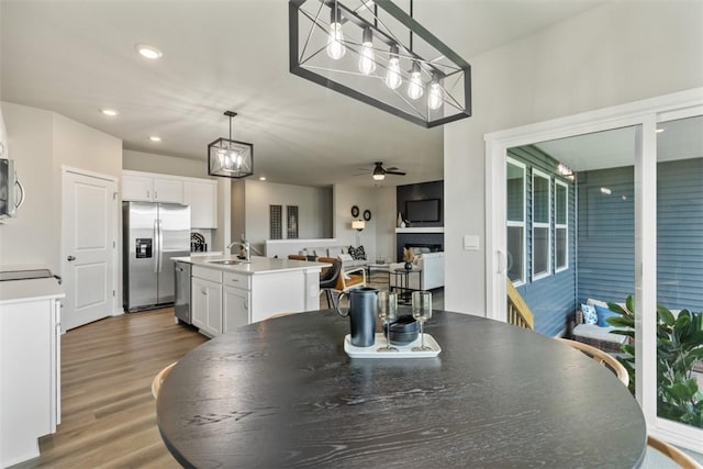 dining room with ceiling fan, sink, and hardwood / wood-style floors