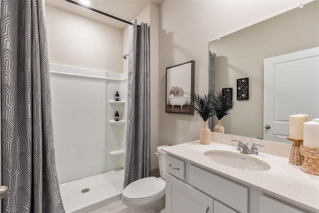 bathroom featuring curtained shower, vanity, and toilet