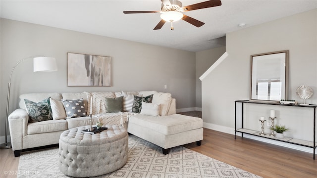 living room with ceiling fan and light hardwood / wood-style flooring