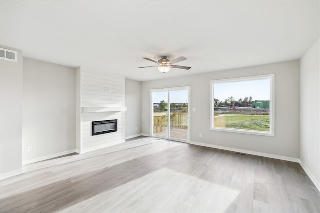 unfurnished living room featuring ceiling fan, light hardwood / wood-style flooring, and a fireplace