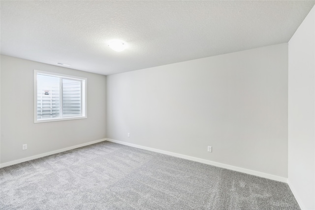 carpeted spare room featuring a textured ceiling