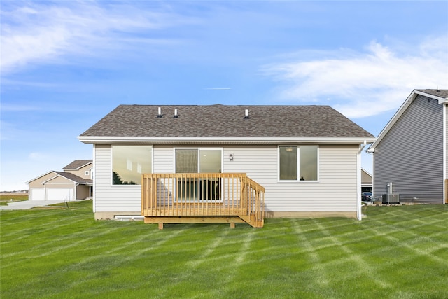 back of property with a wooden deck, a yard, a garage, and cooling unit