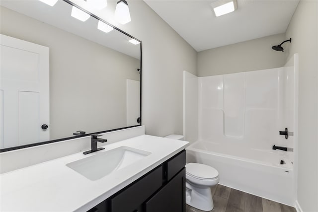 full bathroom with shower / bathing tub combination, hardwood / wood-style floors, vanity, and toilet