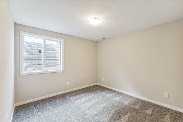 carpeted empty room featuring a textured ceiling