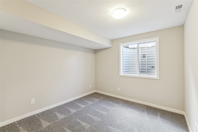 carpeted spare room featuring a textured ceiling