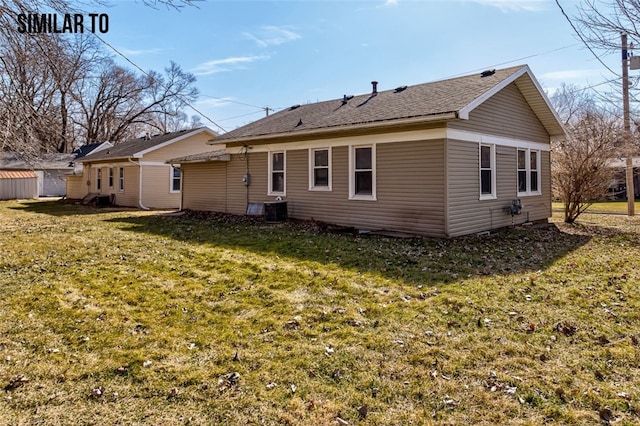 rear view of house featuring a lawn and central AC unit