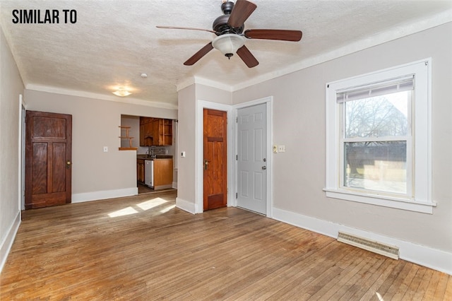 unfurnished living room featuring ceiling fan, a textured ceiling, and hardwood / wood-style flooring