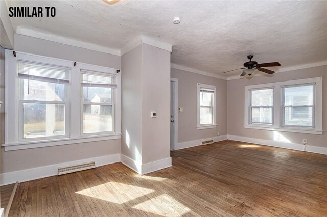 unfurnished room featuring a healthy amount of sunlight, ceiling fan, and hardwood / wood-style flooring