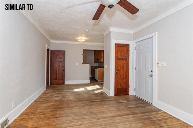 empty room with wood-type flooring, ceiling fan, and a textured ceiling