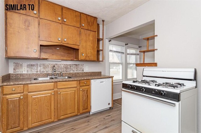 kitchen featuring sink, light hardwood / wood-style flooring, and white appliances