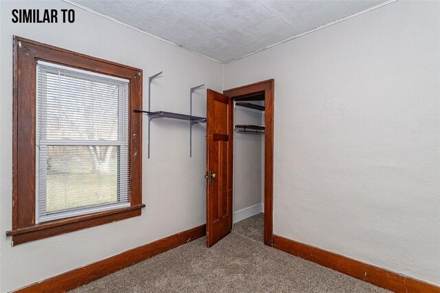 unfurnished bedroom featuring a closet, carpet floors, and multiple windows