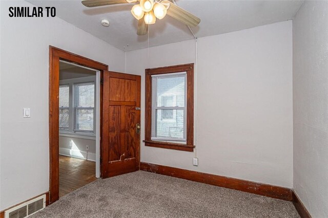 carpeted spare room featuring ceiling fan