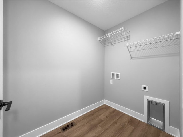 washroom with hookup for a washing machine, dark wood-type flooring, and electric dryer hookup