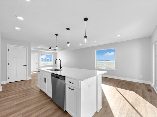 kitchen featuring a center island with sink, stainless steel dishwasher, a healthy amount of sunlight, and sink