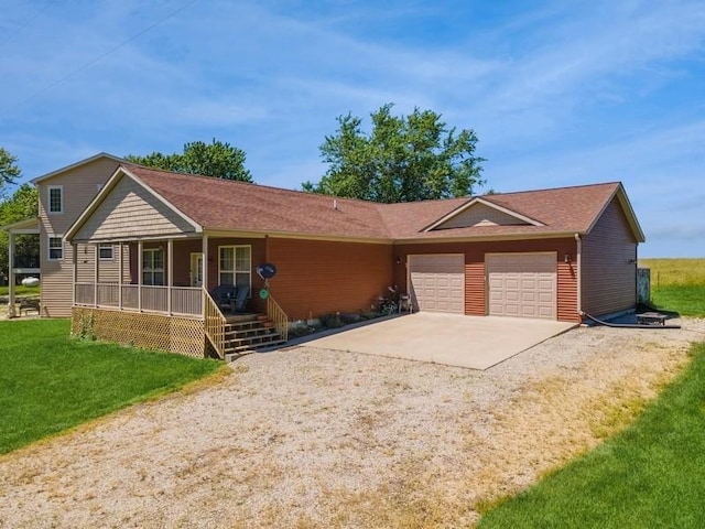 ranch-style home featuring a front lawn, a porch, concrete driveway, and an attached garage