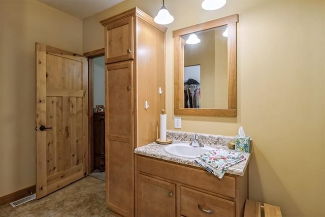 bathroom with visible vents, baseboards, and vanity