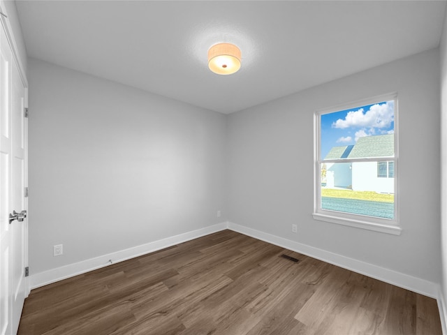 unfurnished room with hardwood / wood-style flooring