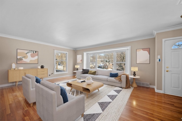 living room featuring crown molding and light hardwood / wood-style flooring