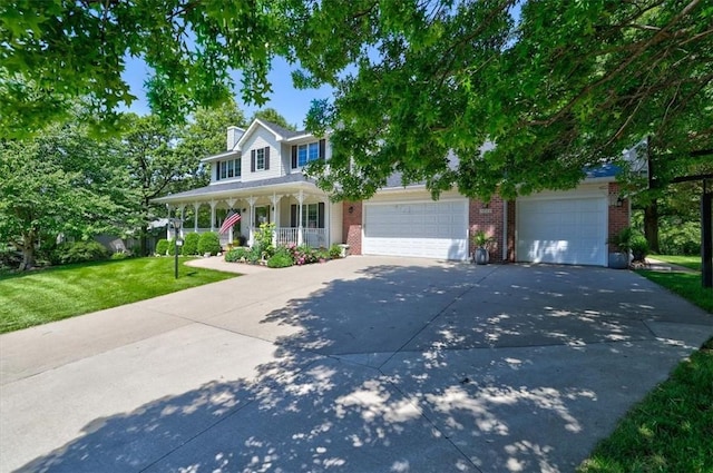 view of front of house with a garage, a front yard, and covered porch