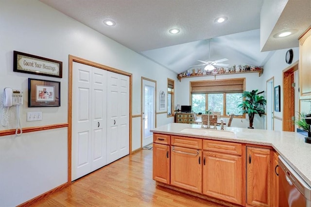 kitchen with lofted ceiling, sink, light hardwood / wood-style flooring, stainless steel dishwasher, and ceiling fan