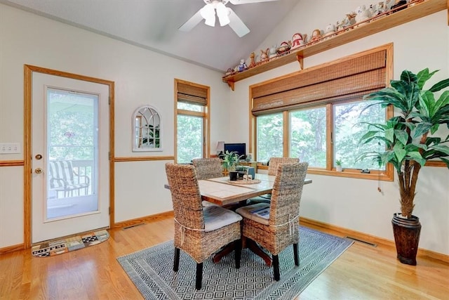 dining space featuring ceiling fan, vaulted ceiling, and light hardwood / wood-style flooring