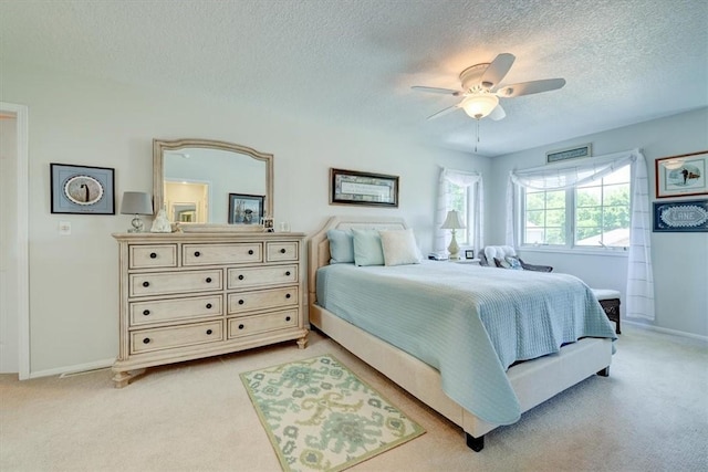 carpeted bedroom with ceiling fan and a textured ceiling