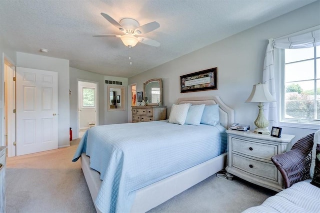 carpeted bedroom with ceiling fan and a textured ceiling