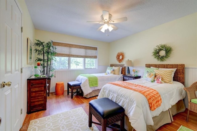 bedroom featuring ceiling fan, a textured ceiling, and light hardwood / wood-style floors