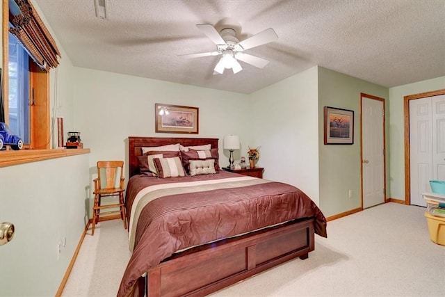 carpeted bedroom featuring ceiling fan and a textured ceiling