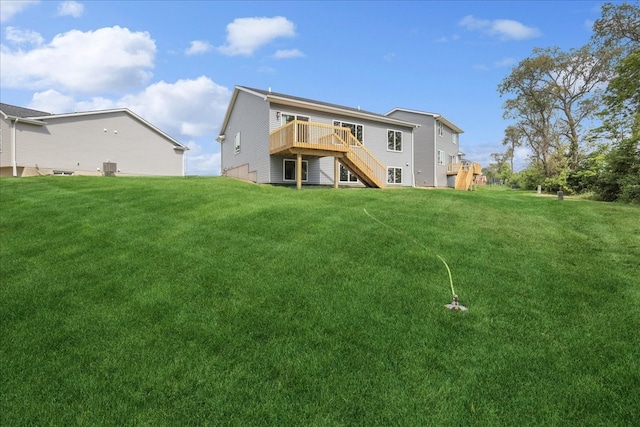 back of house featuring cooling unit, a lawn, a deck, and stairs