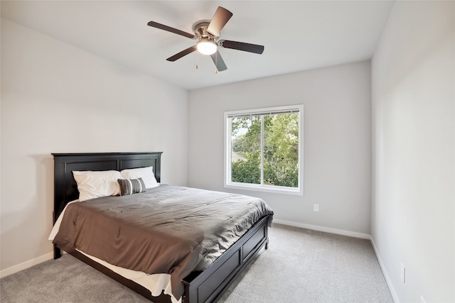 bedroom featuring light carpet, ceiling fan, and baseboards