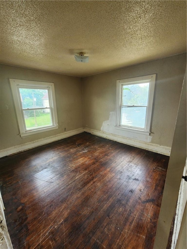 unfurnished room featuring a textured ceiling and dark wood-type flooring