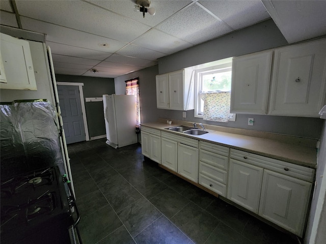 kitchen with sink, a paneled ceiling, white cabinetry, range with gas cooktop, and white fridge