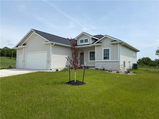 view of front of home with central air condition unit, a front yard, and a garage