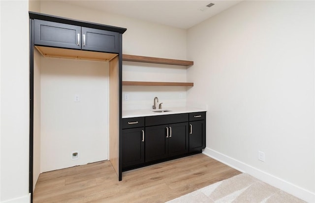 bar featuring sink and light hardwood / wood-style flooring