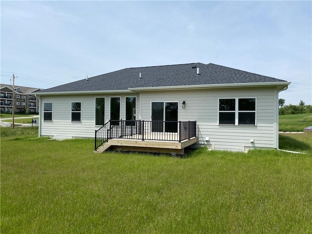 rear view of house with a deck and a lawn